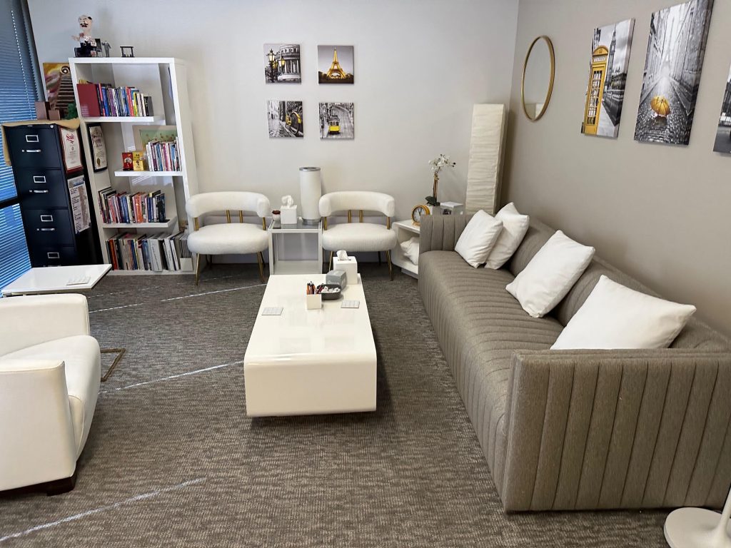 A living room with white couches and a coffee table.